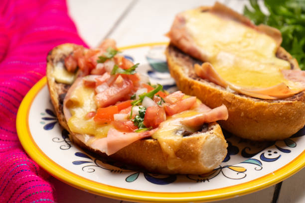 istock Mexican molletes with ham and cheese on white background 1241161930