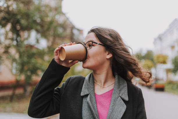 istock Bespectacled lady enjoying hot coffee on windy day 1241163011