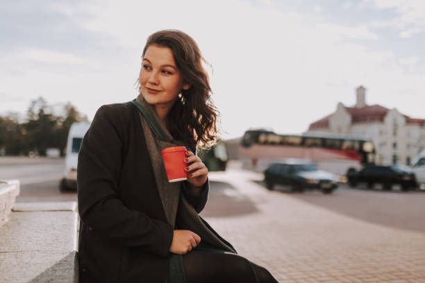 istock Woman sitting outdoors with car on the background 1241173701