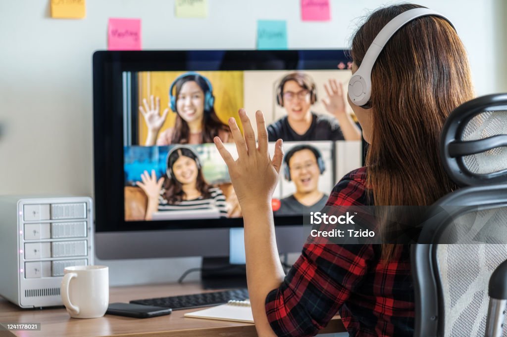 Rear View of Asian Business woman say hello with teamwork colleague in video conference Online meeting, Social distancing and new normal concept, Rear View of Asian Business woman say hello with teamwork colleague in video conference when Coronavirus outbreak E-Learning Stock Photo