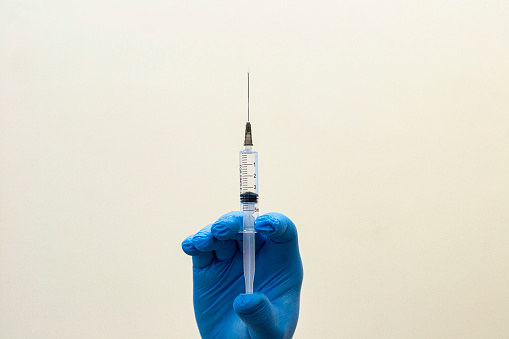 top view of doctor holding syringe with injection