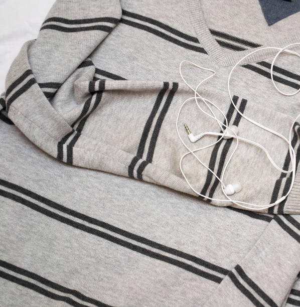 istock white headphones on a striped gray jumper. 1241182763
