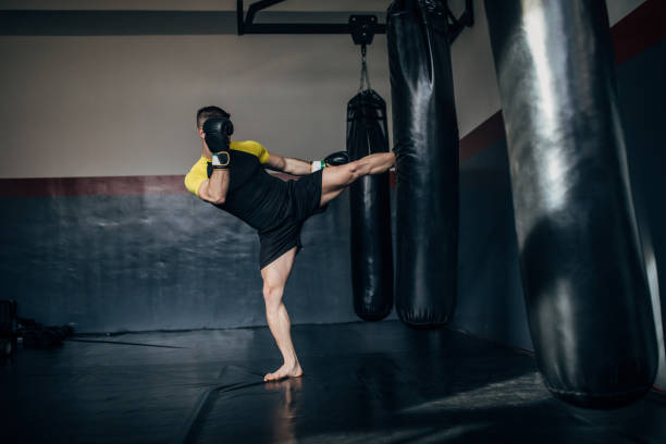 istock Young kickboxer kicking a punching bag 1241188078