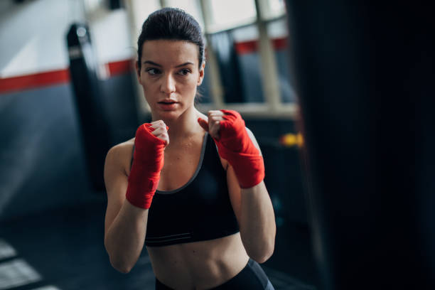 istock Woman kickboxer punching a punching bag 1241190678