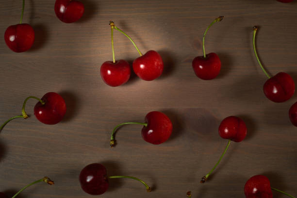 istock Green spring red cherries on wooden background selective focus cherry 1241193861