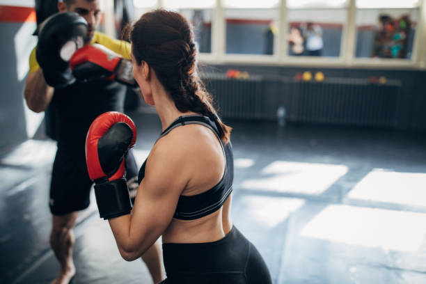 istock One woman kickboxer sparring with her coach 1241197088