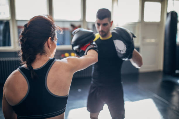 istock Female kickboxer sparring with her coach 1241203465