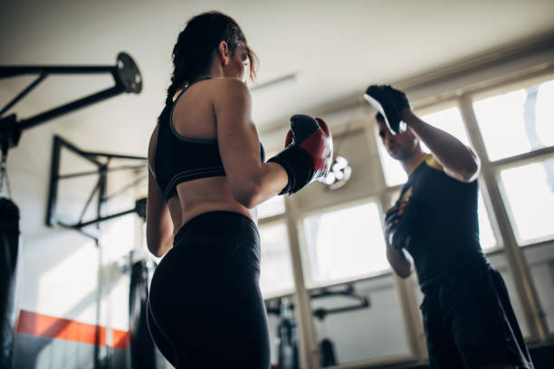 istock Beautiful woman kickboxer sparring with her coach 1241207117