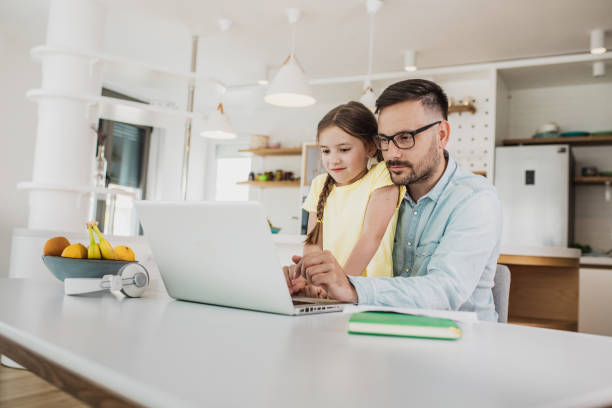istock Father working from home with his daughter in his lap 1241218753