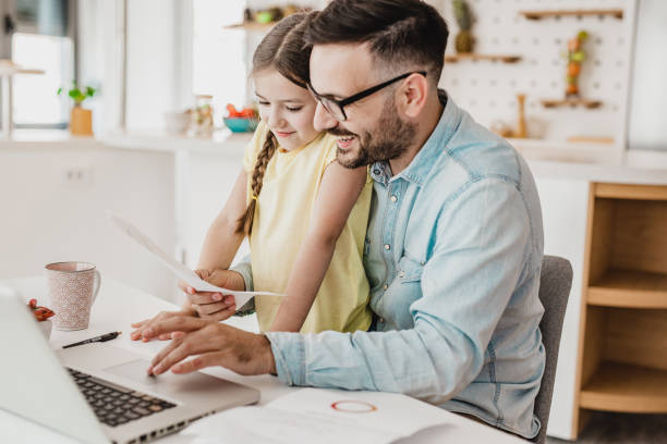 istock Father working from home with his daughter in his lap 1241220359