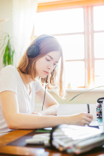 istock Young woman drawing in her room 1241227632