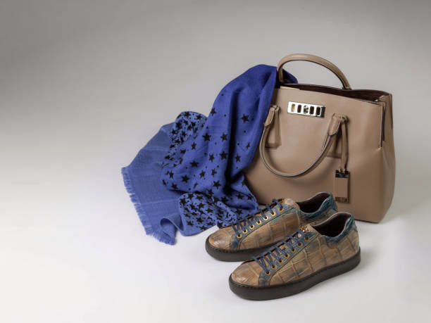 istock Crocodile leather sneakers next to a leather bag and a woolen scarf, side view 1241234003