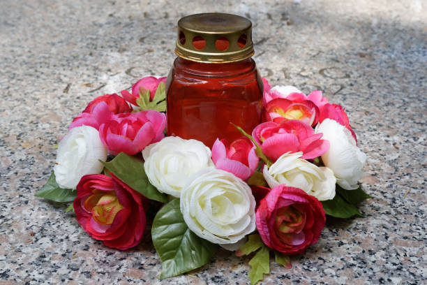 candle and a rose arrangement a grave candle and a rose arrangement on a gravestone pink memorial candle with flowers stock pictures, royalty-free photos & images