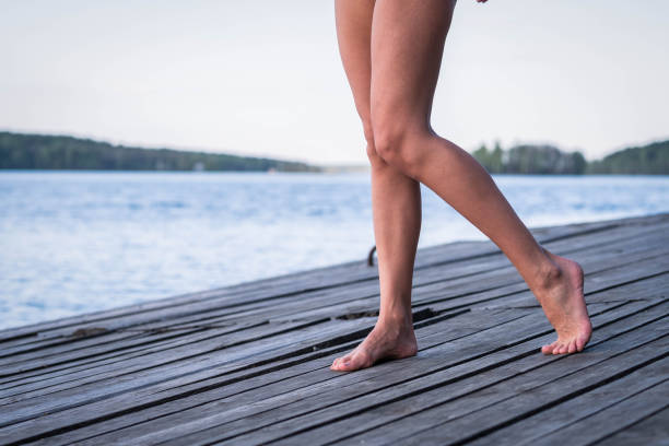 istock Slender tanned legs on a wooden bridge 1241274744