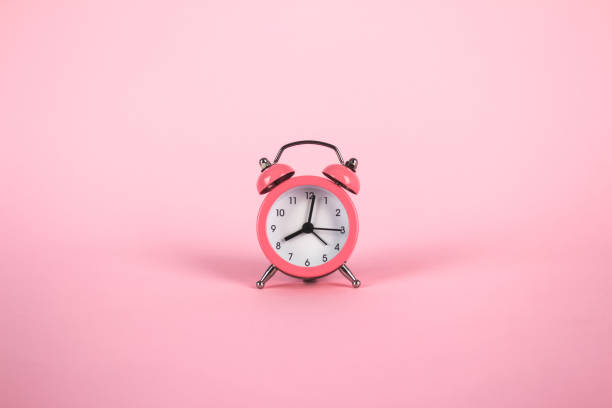istock Pink alarm clock on pink background. Minimalistic flat lay image with copyspace and central composition. Time concept 1241310157
