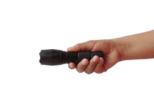 istock Black flashlight in human hands, isolated on a white background with the clipping path. 1241324358