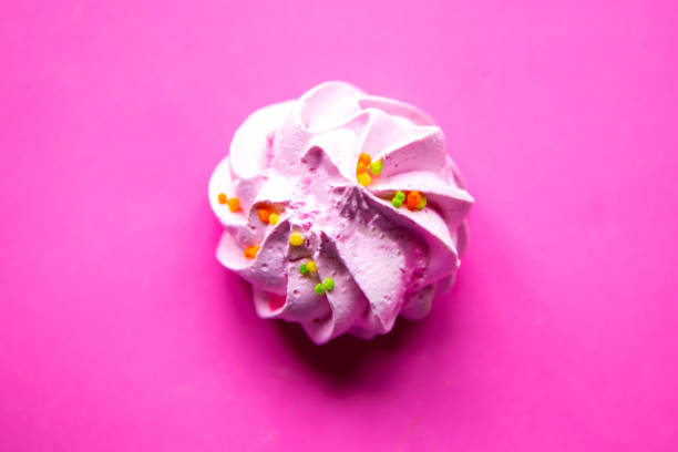istock Tasty fresh meringue on bright pink background, top view 1241329692