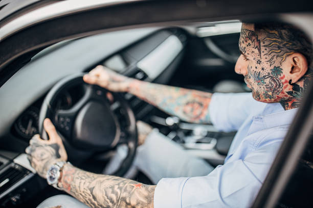 istock Modern tattooed man driving a car 1241330208