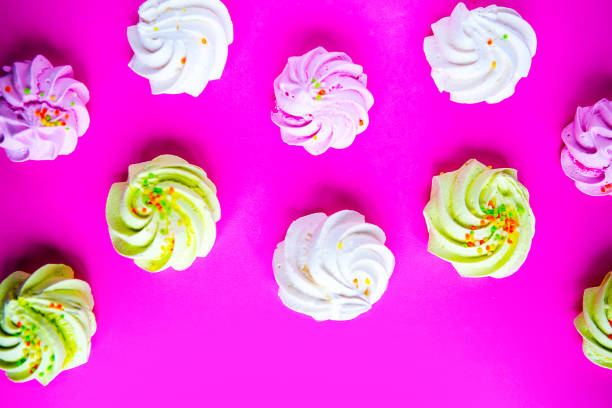 istock Tasty fresh meringue on bright pink background, top view 1241330757