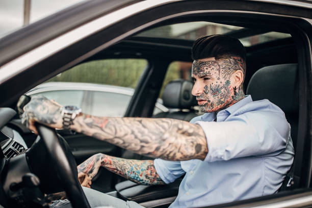 istock Modern tattooed man driving a car 1241330791