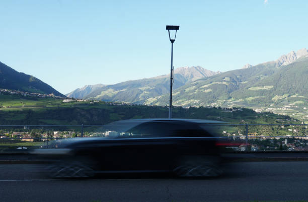 coche en movimiento borroso, pico ifinger en el fondo, merano (bz), italia ciudad por debajo. - ifinger fotografías e imágenes de stock