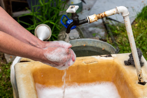 A woman washes her hands after working in the garden. A woman washes her hands after working in the garden. vacation rental cleaning stock pictures, royalty-free photos & images