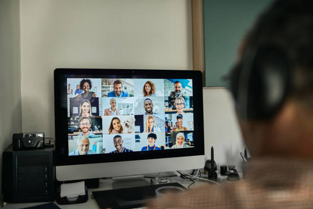 Businessman Working With Colleague Through Video Conferencing Businessman working with colleague through video conferencing from his home during coranavirus lockdown. virtual event stock pictures, royalty-free photos & images