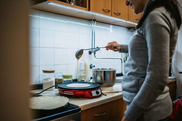 kobieta robi naleśniki - obrotowa łopatka zdjęcia i obrazy z banku zdjęć