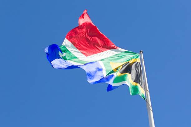 istock huge South african flag flapping in the wind 1241376923