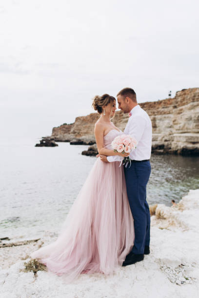 Loving couple on the seashore. Wedding. Newlyweds. Loving couple on the seashore. Wedding.-Image ceremony photos stock pictures, royalty-free photos & images