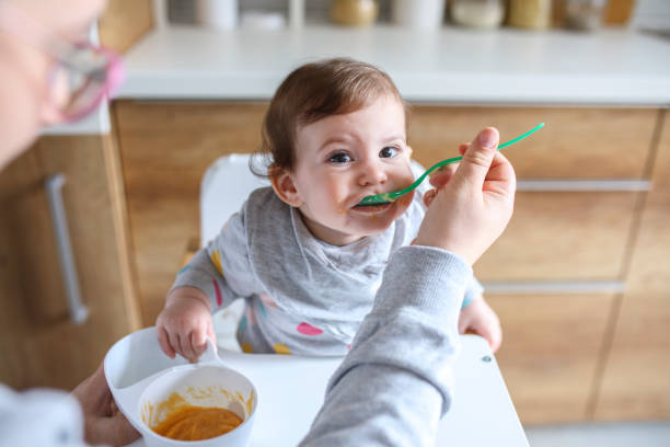 istock Mother feeds baby from spoon 1241398956