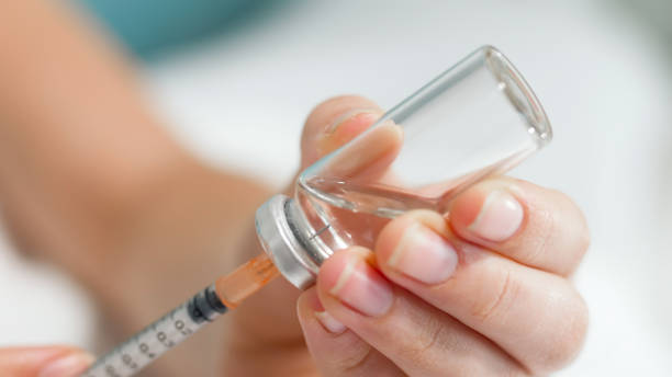 istock Macro image of syringe needle in ampule with medicines 1241403284
