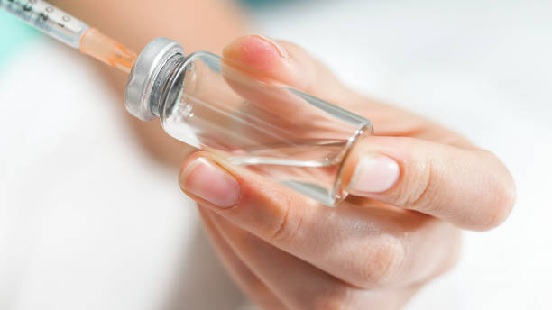 istock Macro image of female nurse preparing syringe for injection 1241403287