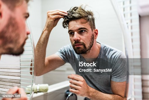 istock Young man stylizing his hair in the bathroom 1241404389