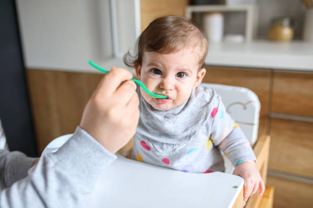 istock Mother feeds baby from spoon 1241404957