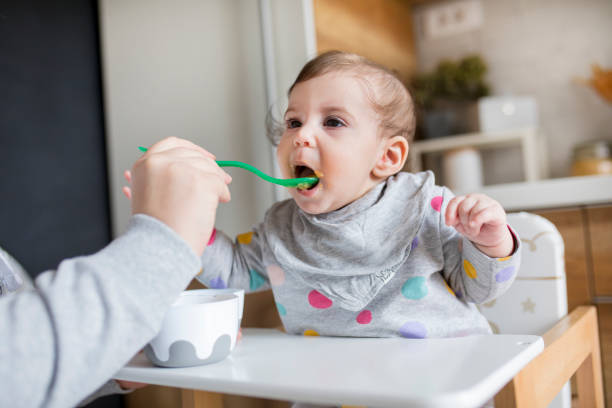 istock Mother feeds baby from spoon 1241409195