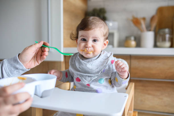 istock Mother feeds baby from spoon 1241411364