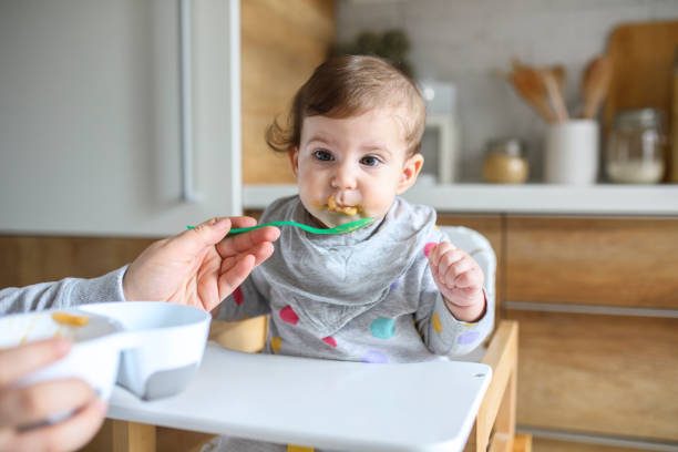 istock Mother feeds baby from spoon 1241412979