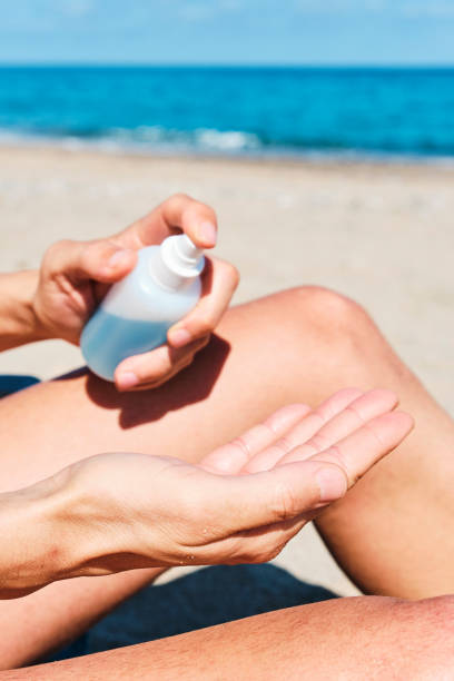 istock man on the beach disinfecting his hands 1241414063