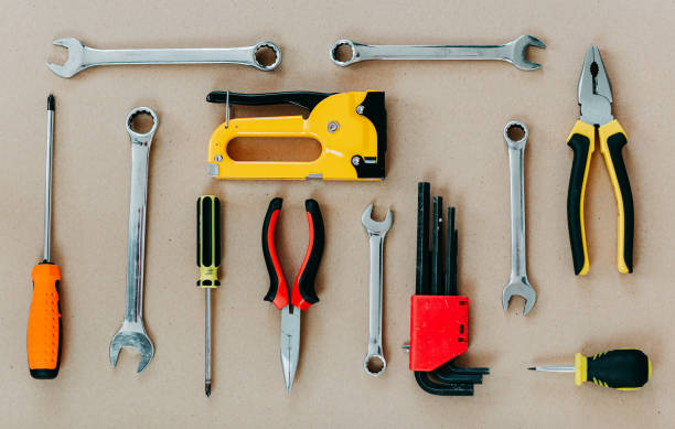 istock Tools top view on craft paper. Plier, open wrenches, screwdrivers and staple gun flat lay. 1241429990