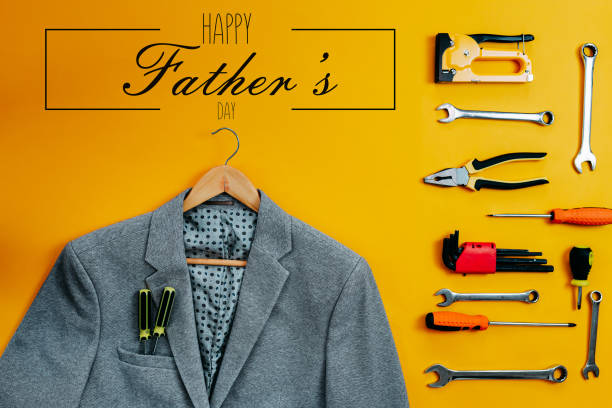 Tools top view on yellow background. Father's day card with tools and suit coat. Plier, open wrenches, screwdrivers and staple gun flat lay. Gray suit coat with screwdrivers from the pocket. herramientas vista superior sobre fondo amarillo. tarjeta del día del padre con herramientas y abrigo de traje. plier, llaves abiertas, destornilladores y pistola de grapas planas. chaqueta de traje gris con destornilladores del bolsillo.