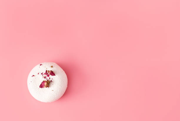 istock One mousse pastry dessert covered with white chocolate and decorated with rose buds on pastel pink background. Modern stylish cake. Flat lay style. Copy space. 1241431166
