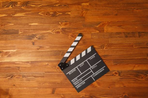 Movie production clapper board over wooden background. Top view. Copy space. stock photo