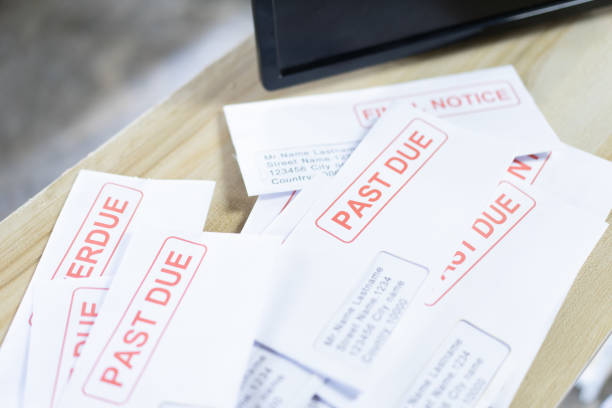 istock Debt letters that are collected on past overdue bills and final announcements on the table. Red writing to represent the struggle against economic unemployment. 1241442381