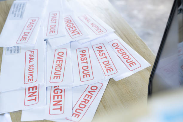 istock Debt letters that are collected on past overdue bills and final announcements on the table. Red writing to represent the struggle against economic unemployment. 1241444046