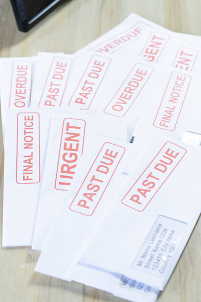 istock Debt letters that are collected on past overdue bills and final announcements on the table. Red writing to represent the struggle against economic unemployment. 1241444636