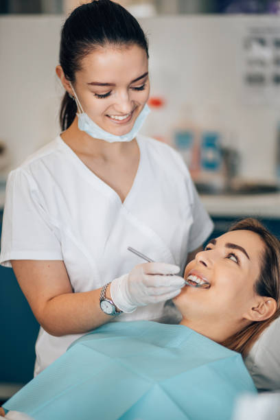istock friendly dentist woman treating patient 1241449803