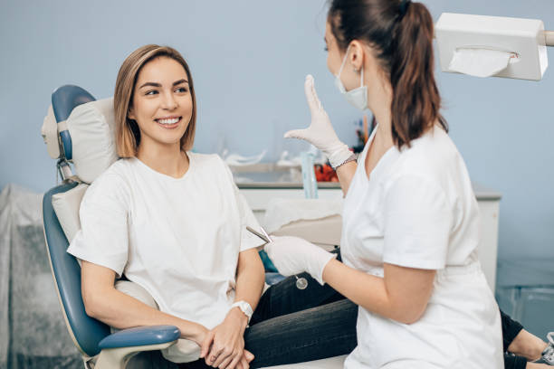 young beautiful woman came to doctor for teeth examination friendly doctor dentist examine teeth of caucasian young woman in casual wear, isolated in dentist office, using special medical equipment general military rank stock pictures, royalty-free photos & images