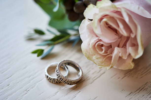 istock Wedding rings lie on the wooden table 1241462583