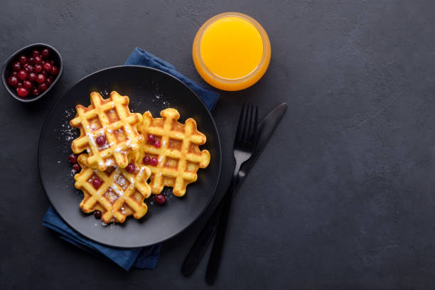 pyszne belgijskie gofry z żurawiną i sokiem pomarańczowym na ciemnym tle - napkin black blank ideas zdjęcia i obrazy z banku zdjęć